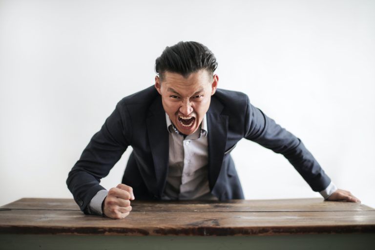 homme en colère qui tape du poing sur la table